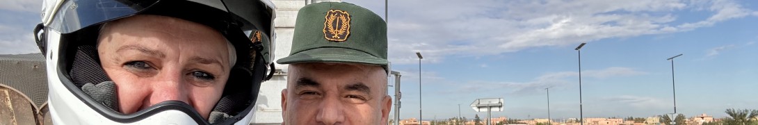 A selfie of myself, wearing a motorbike helmet, and an Algerian policeman